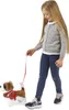 A young girl is walking a toy dog on a leash. Produktbild-Vorschau