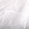Close-up of white lace fabric with floral embroidery. Produktbild-Vorschau
