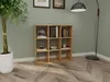 A wooden cube shelf filled with books and decorative items, placed in a room with a green wall and wooden floor. Náhľad obrázku produktu