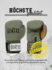 A pair of green boxing gloves with brown accents are displayed against a textured, light gray and white background. Text overlays and a circular graphic highlight quality and guarantee. Produktbild-Vorschau