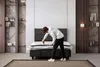 A person is unboxing a mattress in a bedroom. Produktbild-Vorschau