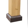 Close-up of the base of a wooden post with a brown metal cap. Produktbild-Vorschau