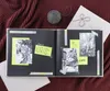 An open scrapbook with photos of cats, yarn, and a book. Podgląd zdjęcia produktu