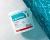 A white bucket of pool chemicals sits on a tiled surface next to a pool of blue water. Produktbild-Vorschau
