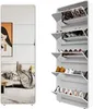 A white shoe cabinet with multiple flip-out drawers, some of which contain shoes. A mirrored panel on the left side reflects a living room scene. Podgląd zdjęcia produktu