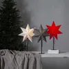 Three star-shaped paper lamps are displayed in front of a Christmas tree and a draped cloth. Podgląd zdjęcia produktu