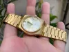 A person's hand holding a gold Tissot PRX watch. Anteprima dell’immagine prodotto