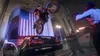 A motorcycle stunt rider jumps over police cars in front of a large American flag. Produktbild-Vorschau