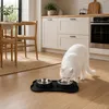 Weiße Katze frisst aus dem schwarzen Doppelnapf in der Küche Produktbild-Vorschau