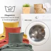 Pillows and bedding in front of a washing machine, with care instructions displayed. Produktbild-Vorschau