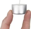 Two fingers holding a small tea light candle. Podgląd zdjęcia produktu