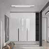 A modern living room with a white, glossy wardrobe and a long, slim LED ceiling light. Voir les images du produit