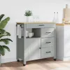 A kitchen cart with drawers and a cabinet, placed in a kitchen setting with a plant and wine glasses. Podgląd zdjęcia produktu