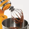 A close-up shot of a KitchenAid stand mixer whisk attachment covered in chocolate batter. Produktbild-Vorschau