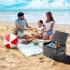 A family is having a picnic on the beach with a cooler box filled with drinks. Anteprima dell’immagine prodotto