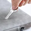 A hand holding a key over a grey laptop sleeve. Anteprima dell’immagine prodotto