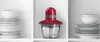 A red and gray food chopper sits on a shelf between stacks of white plates and bowls. Voir les images du produit