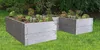 Two raised garden beds filled with plants, set on a grassy lawn with a garden in the background. Voir les images du produit