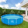 A round, blue metal frame swimming pool filled with water, set up on a green lawn in a backyard with a hedge and a modern house in the background. Náhled obrázku produktu