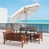 A wooden patio set with a large white umbrella is set up on a balcony overlooking the ocean. Produktbild-Vorschau