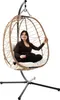 A woman is sitting in a hanging egg chair. Produktbild-Vorschau