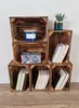 Wooden crates stacked and filled with books, a candle, and a plant. Produktbild-Vorschau