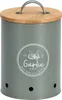 A gray metal garlic keeper with a bamboo lid and a circular graphic on the front. Produktbild-Vorschau