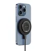 A blue iPhone with a black magnetic charger and ring attached to the back, connected by a black cable. Anteprima dell’immagine prodotto