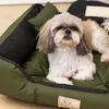 A Shih Tzu dog is lying on a green and black dog bed. Náhled obrázku produktu