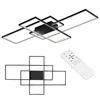 A modern, geometric ceiling light fixture with multiple rectangular frames and a central black box, shown from a slightly elevated angle. A white remote control is placed to the right of the fixture. Produktbild-Vorschau