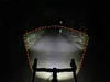 A bicycle's front light illuminating a dark road at night, showing the beam pattern. Produktbild-Vorschau
