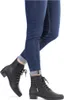 A person wearing blue jeans and black ankle boots. Voir les images du produit