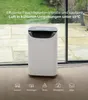 A white dehumidifier is placed on a carpeted floor in front of a large window, with a patio and greenery visible outside. Icons representing different locations are displayed at the bottom. Anteprima dell’immagine prodotto
