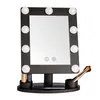 A black makeup mirror with LED lights and a tray for makeup accessories, set against a white background. Produktbild-Vorschau