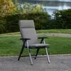 A garden chair with a cushion is placed on a gravel path next to a grassy area, with trees and a body of water in the background. Produktbild-Vorschau
