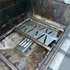 Close-up view of a grill's interior, showing a heat reflector and burner tubes. Podgląd zdjęcia produktu