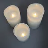 Three white LED candles with glowing flames are arranged on a gray surface. Produktbild-Vorschau