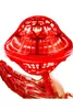 A metallic red robotic hand holds a red, translucent, UFO-shaped toy. Produktbild-Vorschau