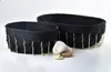 Two black baskets with gold wire bases are shown on a white background, with a few stones in front of them. Náhled obrázku produktu