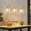 A dining table set with pendant lights hanging above. Produktbild-Vorschau