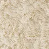 A close-up, top-down view of a cream-colored shaggy rug. Anteprima dell’immagine prodotto