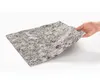 A hand holding a piece of grey, textured material against a white background. Produktbild-Vorschau