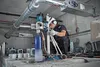 A man is using a diamond drilling machine in an industrial setting. Voir les images du produit