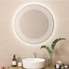 A round LED bathroom mirror with a digital display is mounted on a tiled wall above a sink. Accessories like soap and a plant are placed on the counter. Anteprima dell’immagine prodotto