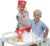 Two children are playing with a doctor's toy set on a table. Produktbild-Vorschau