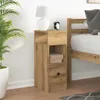 A bedside table next to a bed, with a plant and a lamp. Náhľad obrázku produktu