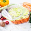 A clear, well-lit shot of a food storage container filled with chopped vegetables, surrounded by other fresh produce on a white surface. Anteprima dell’immagine prodotto