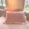Two pink pillows with ruffled edges are placed on a pink surface, with a window and radiator visible in the background. Produktbild-Vorschau