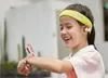 A young girl wearing a smartwatch and earbuds smiles while looking at her wrist. Náhled obrázku produktu