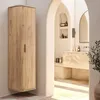 A tall wooden cabinet is shown in a bathroom setting, with an arched doorway leading to a sink and mirror. Podgląd zdjęcia produktu